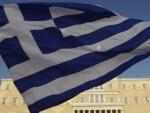 Imagen de archivo de una bandera griega, con el Parlamento del pa&iacute;s al fondo.