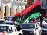 Decenas de personas en sus autos ondean la bandera libia.