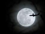 Un avi&oacute;n vuela sobre la Luna llena en la ciudad de Nueva York (Estados Unidos).