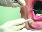 Un dentista revisa la boca de un paciente.