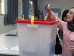 Una mujer libia vota durante las elecciones legislativas que celebra el pa&iacute;s.