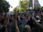 Un millar de funcionarios alza las manos en protesta contra los recortes ante la sede del PP en Madrid.