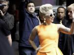 Lady Gaga luciendo un vestido peplum te&ntilde;ido de naranja fl&uacute;or.
