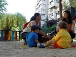 Dos madres con sus hijos en una zona infantil en el barrio del Pilar.