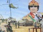 Un joven utiliza un objeto punzante para destruir una pintura mural que representa al l&iacute;der libio, Muamar el Gadafi.
