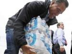 El candidato republicado Mitt Romney levanta botellas de agua en Ohio, donde ayud&oacute; en el suministro de provisiones a los afectados por Sandy.