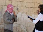 Foto facilitada por la misi&oacute;n de supervisi&oacute;n de la ONU en Siria (UNSMIS), que muestra a un grupo de Observadores de la ONU mientras conversan con un hombre enmascarado.
