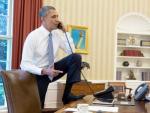 Barack Obama, en su despacho de la Casa Blanca, conversa en una postura muy informal por tel&eacute;fono con Joe Biden de fondo.