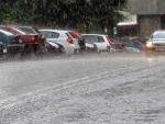 Autom&oacute;viles, circulando bajo la lluvia en Madrid.