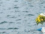 Dos pescadores locales lanzan al mar un ramo de flores en homenaje a las v&iacute;ctimas del naufragio frente a la isla italiana de Lampedusa.