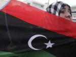 Una mujer porta la bandera de Libia en una manifestaci&oacute;n en Misrata.