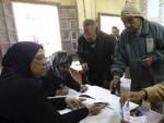 Dos hombres se registran para poder participar en el referendo sobre la nueva Constituci&oacute;n en el barrio de Abassyia, en El Cairo (Egipto).