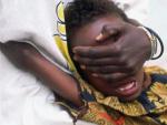 Una ni&ntilde;a de seis a&ntilde;os grita de dolor mientras le practican una mutilaci&oacute;n genital en Somalia. Su hermana de 18 a&ntilde;os la sostiene.