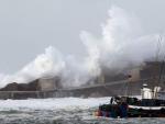 Grandes olas rompen un tramo del dique del puerto de Cudillero. Una borrasca mantiene en alerta a cuarenta provincias de quince comunidades.