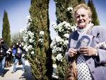 Una mujer sostiene una foto de una de las v&iacute;ctimas durante el homenaje, en el Bosque del Recuerdo del parque del Retiro, a los 191 fallecidos en los atentados del 11M.