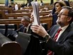 El presidente del Gobierno, Mariano Rajoy (d), consulta unos documentos en una sesi&oacute;n de control.