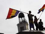 Varios j&oacute;venes ondean la bandera republicana en la Puerta del Sol de Madrid.