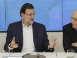 El jefe del Ejecutivo, Mariano Rajoy (i), conversa con el ministro de Hacienda, Crist&oacute;bal Montoro, al inicio de la reuni&oacute;n que preside en la sede nacional del PP para explicar la reforma fiscal.