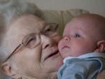 Una abuela levanta en brazos a su nieto.