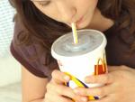 Una joven bebe un refresco grande en un local de comida r&aacute;pida de McDonald's.