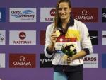La espa&ntilde;ola Mireia Belmonte posa en el podio tras una prueba de la Copa del Mundo de Nataci&oacute;n en Doha. La nadadora consigui&oacute; tres medallas de oro y una plata.