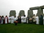 Un grupo de druidas representan una danza durante una ceremonia pagana en el conjunto megal&iacute;tico de Stonehenge (Inglaterra).