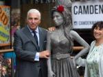 El padre de la cantante posa junto a la estatua de su hija en el barrio de Camden, en Londres.