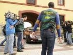 Agentes de la Unidad Central Operativa (UCO) de la Guardia Civil protegen la salida de un veh&iacute;culo en la sede de la Diputaci&oacute;n Provincial de Sevilla
