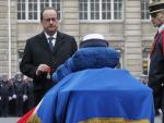 El presidente franc&eacute;s sostiene una medalla drente al ata&uacute;d de la polic&iacute;a Clarissa Jean-Philippe.