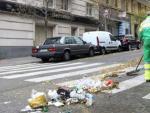 Personal del servicio de limpiezas de Madrid limpia los residuos urbanos acumulados en una calle.