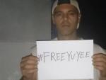 Frank Cuesta sostiene una pancarta con el hashtag de apoyo a su esposa, #FreeYuyee.