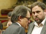 El presidente de la Generalitat, Artur Mas, y el l&iacute;der de ERC, Oriol Junqueras, conversan en el hemiciclo del Parlamento catal&aacute;n.