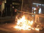 Un joven forma barricadas con vallas y contenedores ardiendo durante los incidentes por el desalojo de Can Vies, en Barcelona.