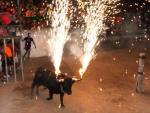 Un toro embolado durante una fiesta mayor en una poblaci&oacute;n tarraconense.