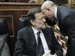 El presidente del Gobierno, Mariano Rajoy, en su esca&ntilde;o, escucha al ministro de Educaci&oacute;n, Cultura y Deportes, Jos&eacute; Ignacio Wert (d), al inicio del debate de los Presupuestos Generales del Estado para 2013.