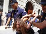 Agentes de la Polic&iacute;a Nacional detienen a una mujer tras la carga contra las protestas del 15-M ante Les Corts Valencianes.