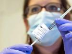 Una enfermera sostiene una dosis de una vacuna experimental contra el &eacute;bola, denominada &quot;cAd3-EBOZ Lau&quot;, antes de inyect&aacute;rsela a un voluntario de una ONG en el Hospital Universitario de Lausana (Suiza).