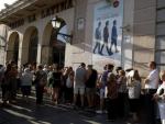 Numerosas personas guardan cola a la entrada del Teatro La Latina.