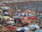 Cientos de personas disfrutan del sol en la playa de la Malvarrosa (Valencia).