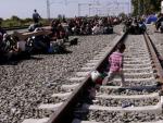 Un ni&ntilde;o cruza las v&iacute;as del tren mientras los refugiados esperan ser registrados en un campamento en la ciudad de Presevo, en el sur de Serbia.
