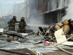 Bomberos apagan el incendio ocasionado tras accidentarse un avi&oacute;n bimotor el domingo 18 de octubre de 2015 en Bogot&aacute; (Colombia).
