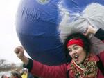 Una manifestante lleva a sus espaldas un globo terr&aacute;queo hinchable durante una protesta durante la Cumbre del Clima de Par&iacute;s.