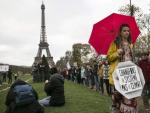 Una activista, junto a Torre Eiffel de Par&iacute;s, antes de la aprobaci&oacute;n del acuerdo por el cambio clim&aacute;tico.