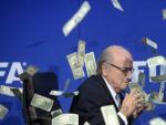 El presidente de la FIFA, Joseph Blatter, bajo una lluvia de billetes que le lanz&oacute; el humorista brit&aacute;nico Simon Brodkin, durante una rueda de prensa para presentar los resultados de la reuni&oacute;n del Comit&eacute; Ejecutivo de la FIFA en su sede de Z&uacute;rich, Suiza.