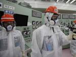 Un grupo de trabajadores de la empresa TEPCO, propietaria de Fukushima, comprueba la radiactividad de la planta nuclear en una de las salas de control de un reactor de la central.