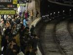 Usuarios del Metro de Barcelona esperan en el and&eacute;n de la estaci&oacute;n de Plaza Espa&ntilde;a.