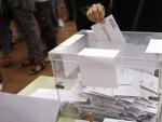 Imagen de una persona depositando su voto en una urna de un colegio electoral de Barcelona.