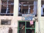 Un hombre habla por su tel&eacute;fono m&oacute;vil desde la entrada a su tienda da&ntilde;ada por un atentado con bomba cerca del Ministerio de Defensa en Kabul (Afganist&aacute;n).