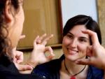 Dos mujeres usan la lengua de signos en la Universidad de Sevilla.
