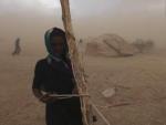 Una mujer Tuareg fija su tienda durante una tormenta de arena en Ingal, N&iacute;ger.
